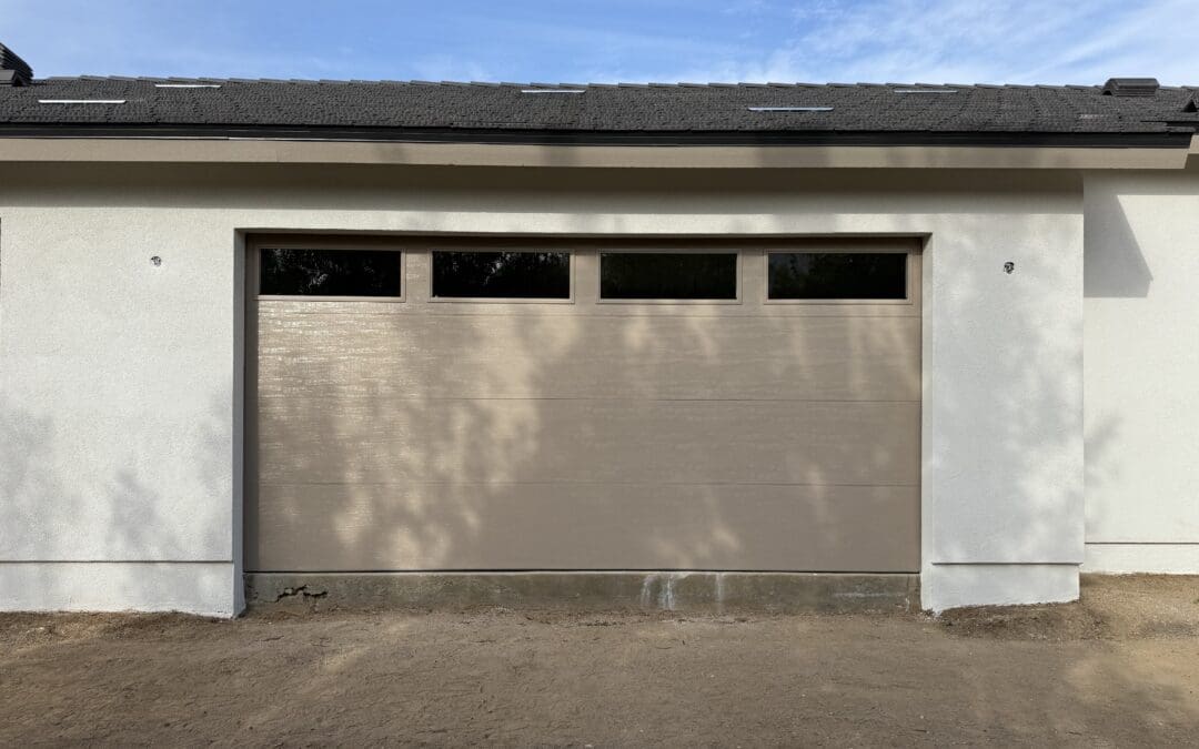 Elegant neutral-toned garage door with realistic wood grain finish and upper window inserts, completed installation at a high-end Canyon Country residence.