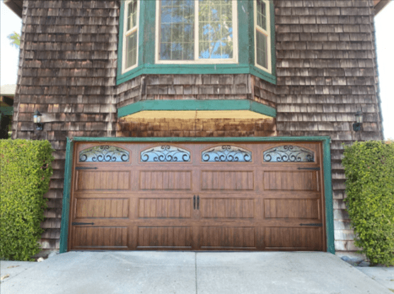 A walnut-finish steel garage door design perfectly matched to the home’s architecture, featuring professional installation by Archway Garage Doors in Canyon Country.