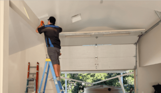 Garage door repair technician fixing broken garage door springs at a Tarzana home by Archway Garage Doors